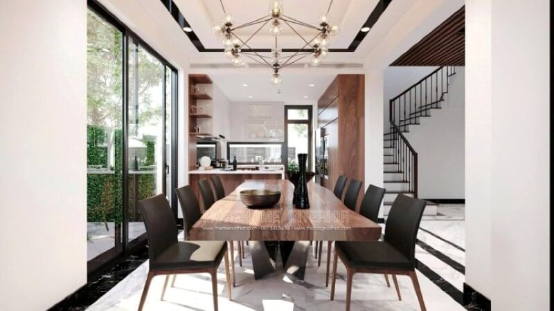 Không chỉ là nơi để mọi người thưởng thức những tinh hoa ẩm thực từ người mẹ, người vợ, người bà,.. mà còn là nơi để gia đình vun đắp nên mái ấm hạnh phúc. Việc chú tâm vào bố trí một không gian phòng ăn biệt thự lại càng được chú trọng để tạo nên điều kiện tốt nhất cho tất cả mọi người trong gia đình. Việc trang trí, lựa chọn đồ nội thất hợp với lối sống, gu thẩm mỹ và bố trí ánh sáng lại ngày càng được chú trọng. Tùy từng sở thích của mỗi mái ấm mà sẽ có những ý tưởng bố trí nội thất phòng ăn phù hợp chẳng hạn với mẫu thiết kế nội thất không gian phong cách hiện đại trong biệt thự Vinhomes Imperia Hải Phòng. Chất liệu gỗ đặc biệt là gỗ óc chó tự nhiên được thể hiện liền mạch dọc tầm nhìn khi vào từ phòng khách, chiếc bàn gỗ óc chó nguyên tấm, chiếc ghế bọc da sử dụng khung gỗ óc chó, dóng sang hai bên là tủ bếp gỗ óc chó, cùng kệ để đồ bắt mắt.